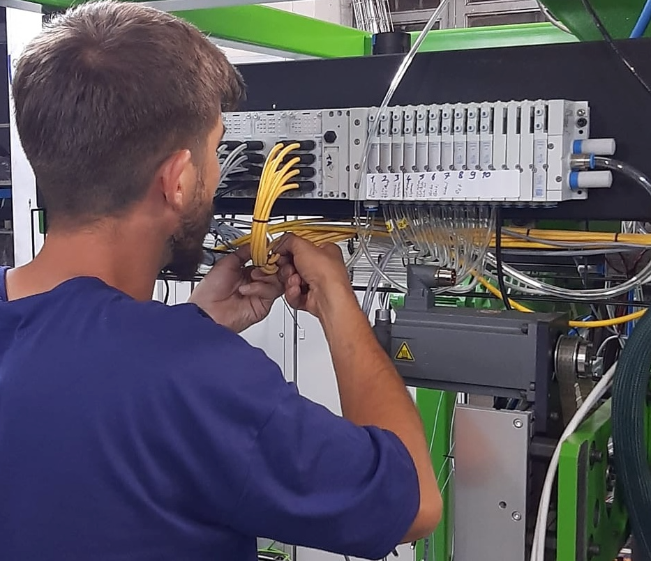An engineer working on electrical wiring of a control panel.